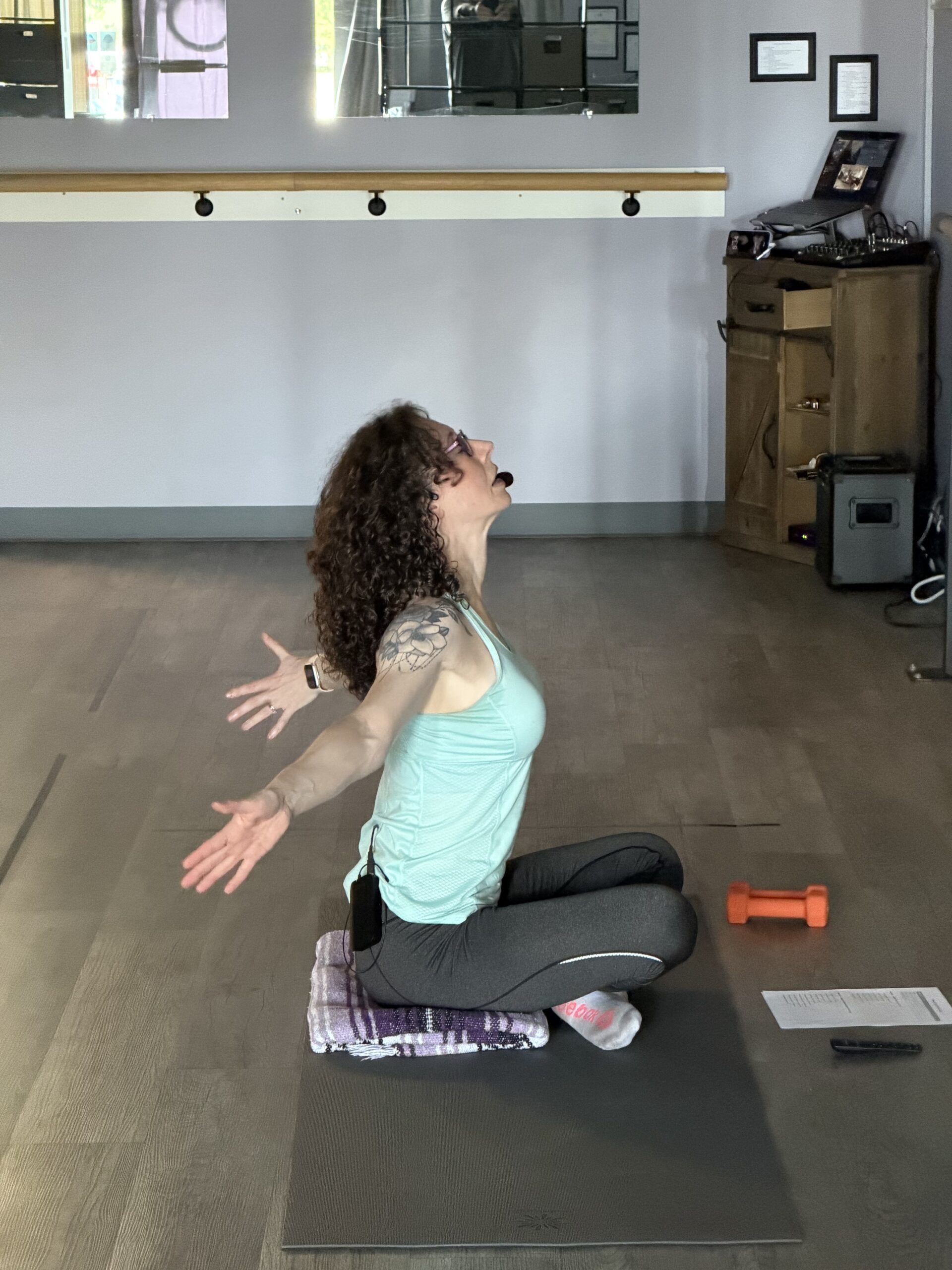 Woman - Stephanie - leading yoga class with open arms